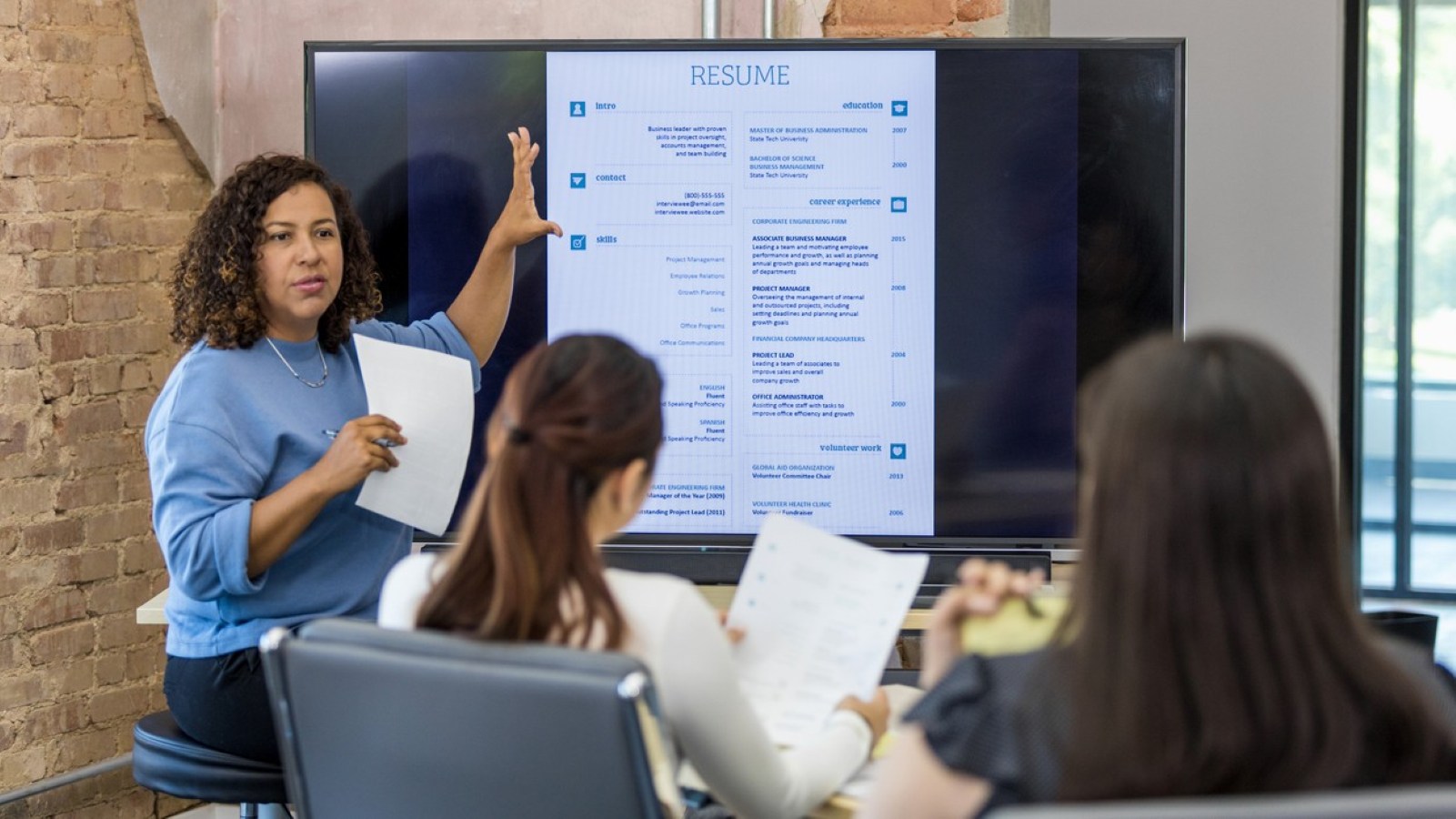 adult human resources representative leads a resume building class stock photo